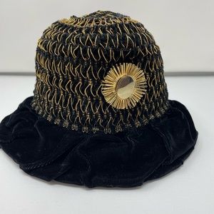 Black velvet hat with gold thread detail.